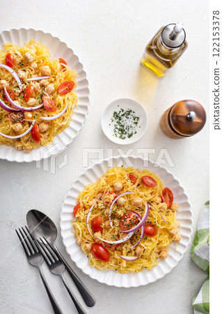 Spaghetti squash with chickpeas and tomatoes topped with red onion, low carb vegan recipe idea 122153378