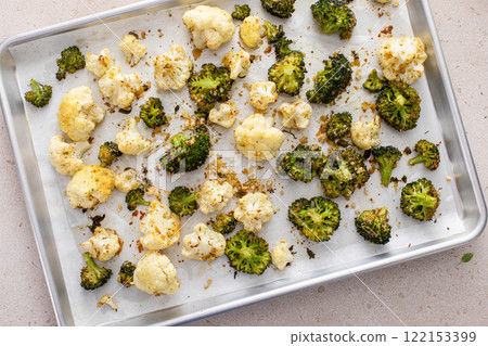 Broccoli and cauliflower roasted on a baking sheet with herbs 122153399