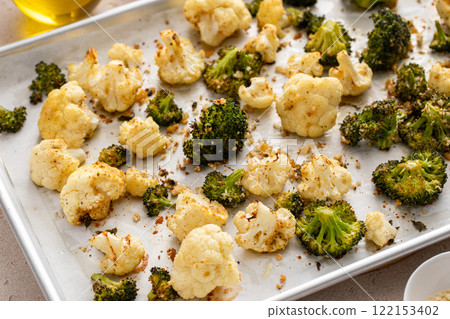 Broccoli and cauliflower roasted on a baking sheet with herbs 122153402
