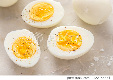 Soft boiled eggs cut in half with salt and pepper Soft boiled eggs cut in half with salt and pepper 122153451