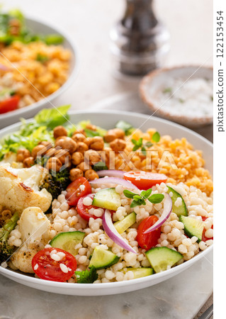 Vegan lunch bowl with lentils, roasted vegetables and chickpeas, pearl couscous salad Vegan lunch bowl with lentils, roasted vegetables and chickpeas, pearl couscous salad 122153454