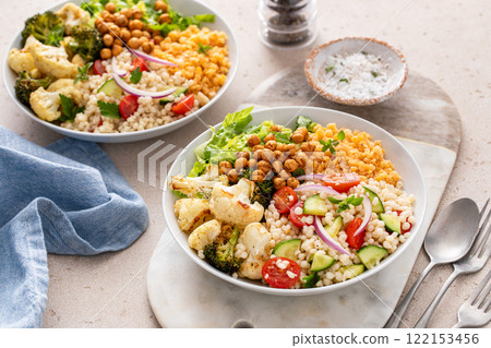 Vegan lunch bowl with lentils, roasted vegetables and chickpeas, pearl couscous salad 122153456