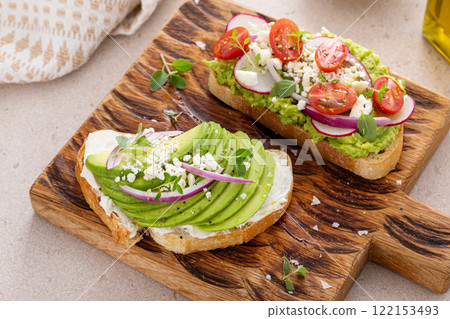 Fresh avocado toasts on wooden board Fresh avocado toasts on wooden board 122153493