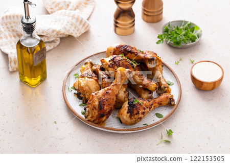 Juicy roasted or grilled chicken drumsticks on plate 122153505