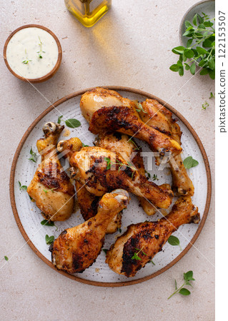 Juicy roasted or grilled chicken drumsticks on plate 122153507