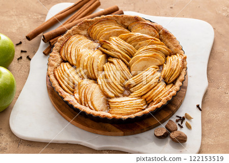 Apple pie or tart filled with sliced apples arranged on a pie base Apple pie or tart filled with sliced apples arranged on a pie base 122153519