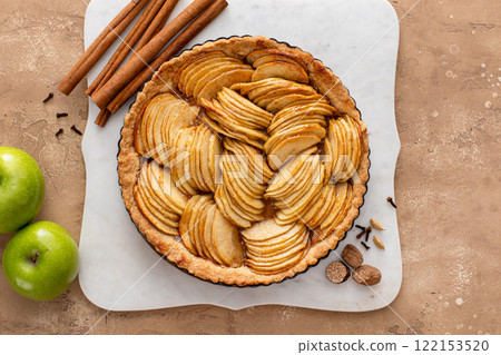 Apple pie or tart filled with sliced apples arranged on a pie base 122153520