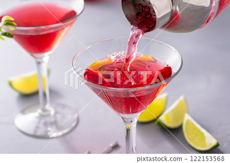 Martini cocktail with cranberry juice garnished with lime twist 122153568