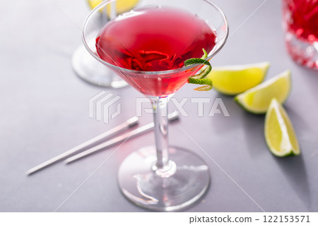 Martini cocktail with cranberry juice garnished with lime twist 122153571
