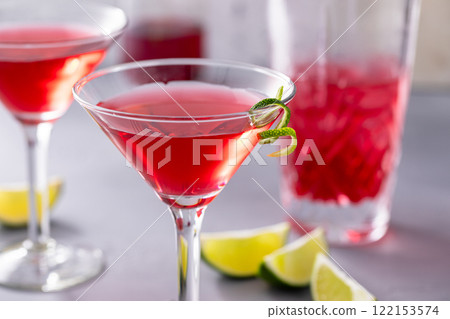 Martini cocktail with cranberry juice garnished with lime twist Martini cocktail with cranberry juice garnished with lime twist 122153574