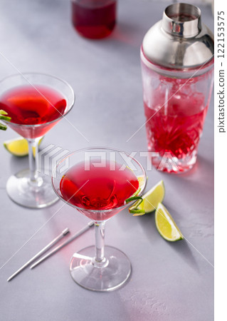 Martini cocktail with cranberry juice garnished with lime twist 122153575