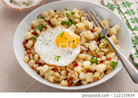 Classic breakfast potato hash with fried egg and ham or bacon 122153654