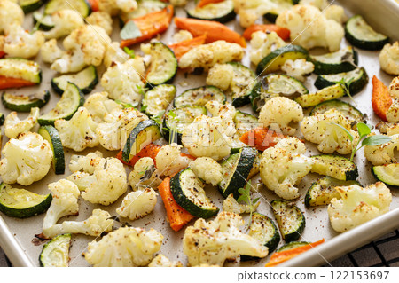 Roasted vegetables on baking sheet with cauliflower, zucchini, and carrots Roasted vegetables on baking sheet with cauliflower, zucchini, and carrots 122153697