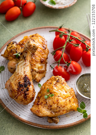 Roasted chicken drumsticks and thighs with pesto and tomatoes 122153708
