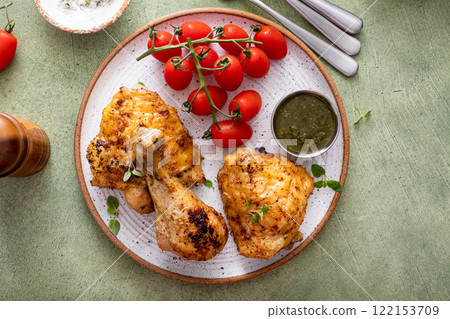 Roasted chicken drumsticks and thighs with pesto and tomatoes 122153709