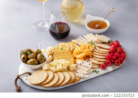Cheese and snacks board with olives and crackers Cheese and snacks board with olives and crackers 122153723