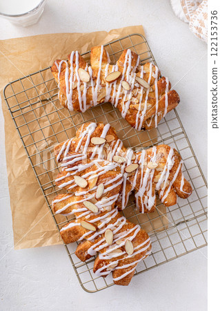 Bear claws pastry drizzled with sugar glaze and topped with almonds 122153736