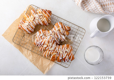 Bear claws pastry drizzled with sugar glaze and topped with almonds 122153739