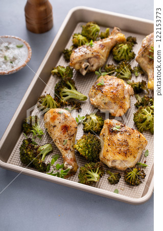 Chicken drumsticks and thighs with broccoli sheet pan dinner or lunch 122153773