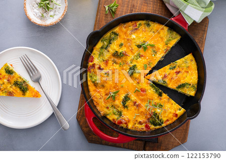 Healthy frittata or quiche with broccoli and red pepper cut in a cast iron pan Healthy frittata or quiche with broccoli and red pepper cut in a cast iron pan 122153790