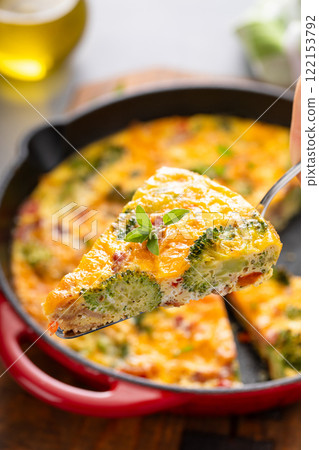 Healthy frittata or quiche with broccoli and red pepper cooked in a cast iron pan 122153792