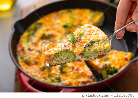 Healthy frittata or quiche with broccoli and red pepper cooked in a cast iron pan Healthy frittata or quiche with broccoli and red pepper cooked in a cast iron pan 122153793