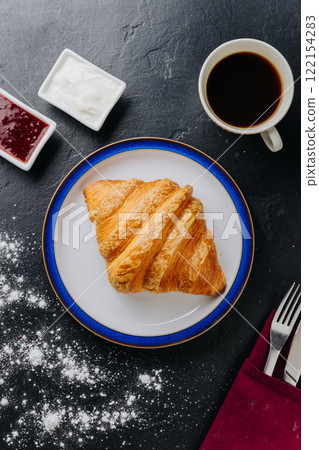 Classic croissant with jam, cream, and coffee for a perfect breakfast treat 122154283