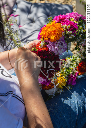 Pregnant woman weaving a floral wreath in a sunny garden at home Pregnant woman weaving a floral wreath in a sunny garden at home 122155195