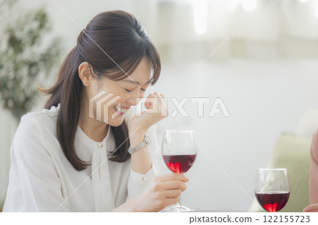 Woman holding a glass of alcohol in the living room 122155723