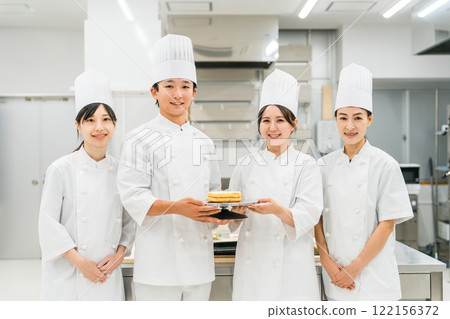 Chefs and cooks in chef coats standing in the kitchen Chefs and cooks in chef coats standing in the kitchen 122156372