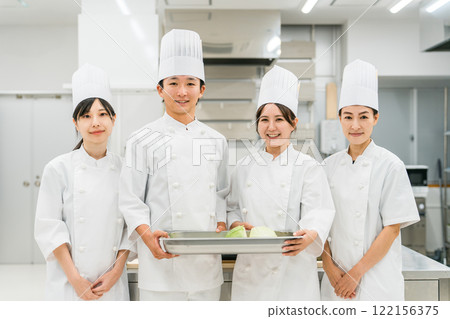 Chefs and cooks in chef coats standing in the kitchen Chefs and cooks in chef coats standing in the kitchen 122156375