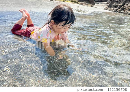 Summer memories of a girl playing in the sea 122156708