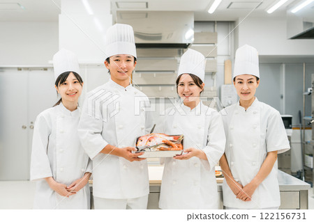 Chefs and cooks in chef coats standing in the kitchen 122156731