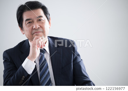 A worried senior business owner with his hand on his chin A worried senior business owner with his hand on his chin 122156977