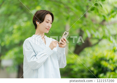 A woman listening to music in the fresh green 122157200