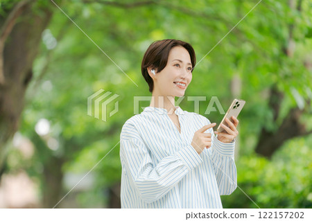 一個女人在新鮮的綠色中聽音樂 122157202