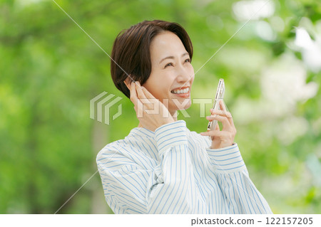 A woman listening to music in the fresh green 122157205