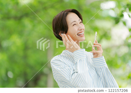 A woman listening to music in the fresh green 122157206