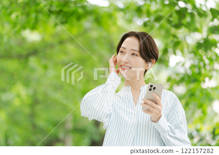 一個女人在新鮮的綠色中聽音樂 122157282