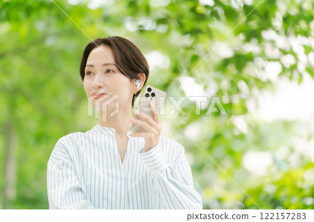 一個女人在新鮮的綠色中聽音樂 122157283