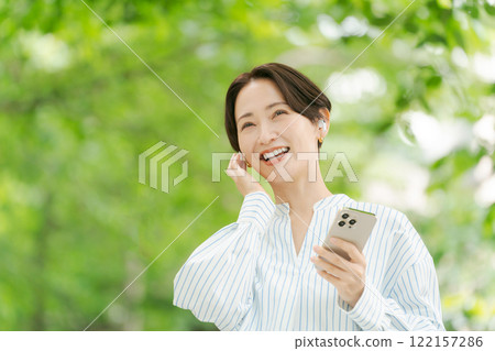 一個女人在新鮮的綠色中聽音樂 122157286