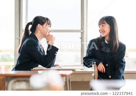 Junior high school girls having a conversation in a school classroom 122157841