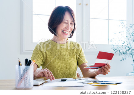 一名中年婦女一邊看存摺，一邊準備報稅 122158227