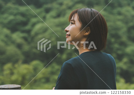 一座被新鮮綠色植物覆蓋的山和一位年輕女子 122158330