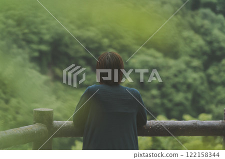 一座被新鮮綠色植物覆蓋的山和一位年輕女子 122158344