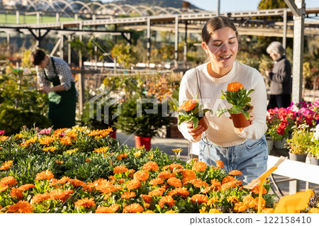 Woman choosing pots with calendula 122158410