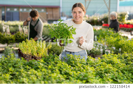 Woman holding peas with mint in her hands 122158414