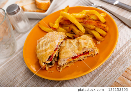 Dish of Spanish cuisine is goat cheese and pepper booklets with French fries Dish of Spanish cuisine is goat cheese and pepper booklets with French fries 122158593