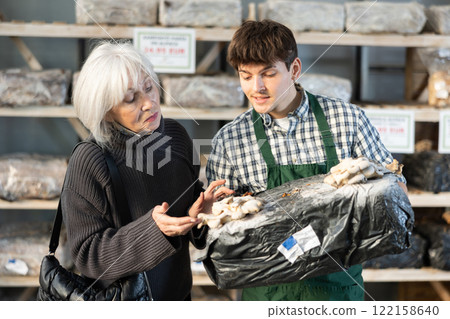 Older woman choosing mycelium in a garden store Older woman choosing mycelium in a garden store 122158640