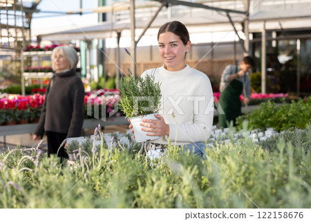 Woman choosing a pot with a lavender bush Woman choosing a pot with a lavender bush 122158676